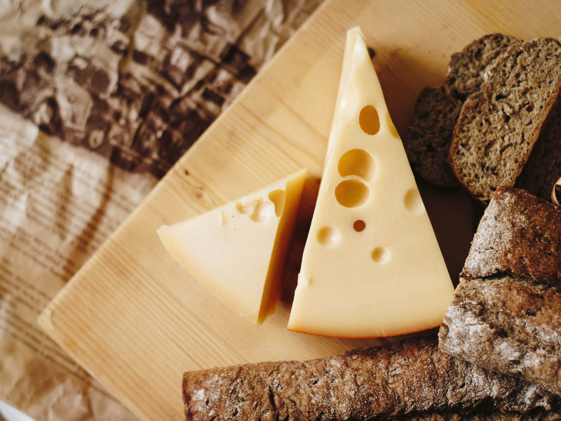 Cheese wedges and sliced bread illustrating food applications relevant to nisin preservation.