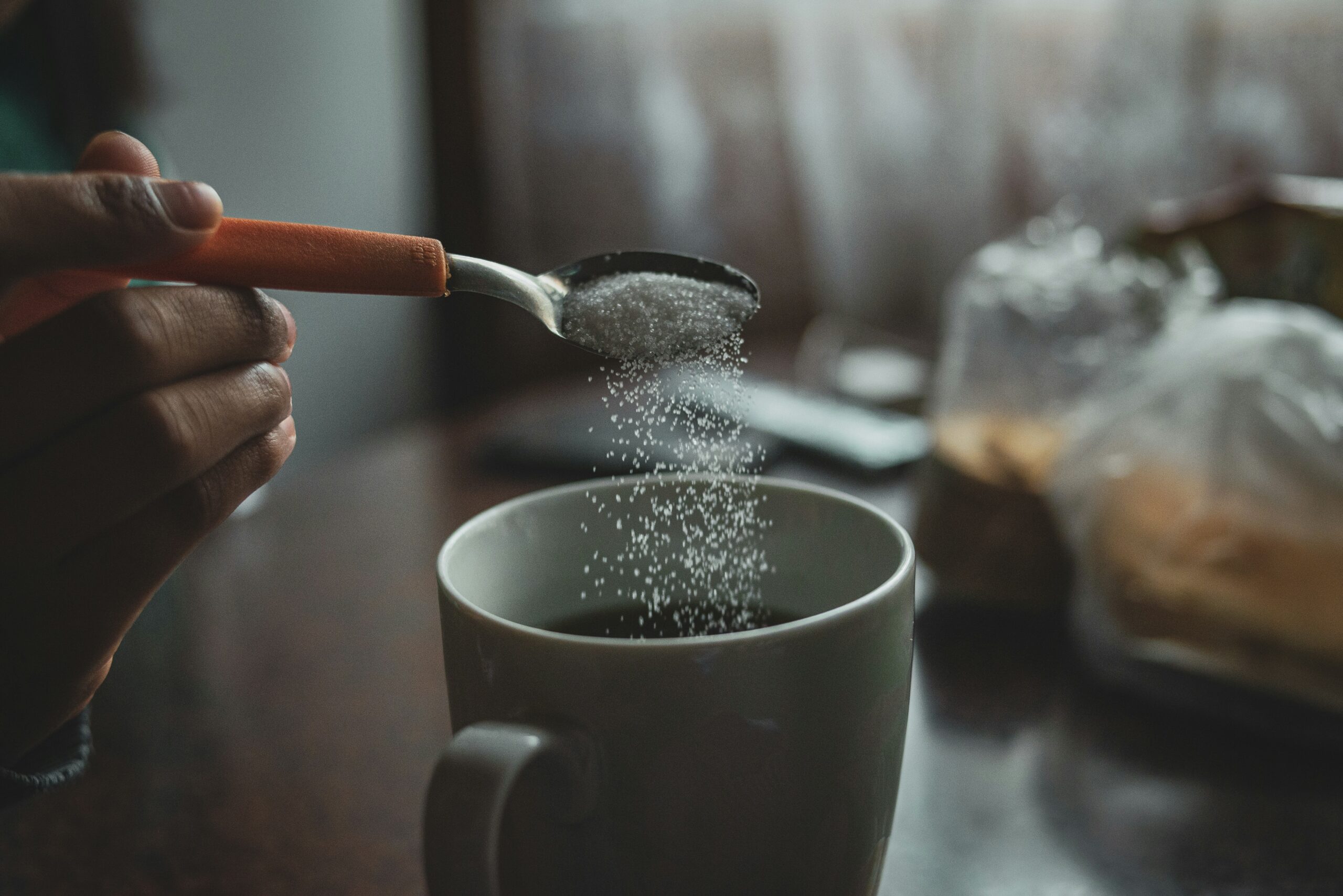 Sucralose powder being added to a beverage — zero-calorie sweetener for food manufacturers